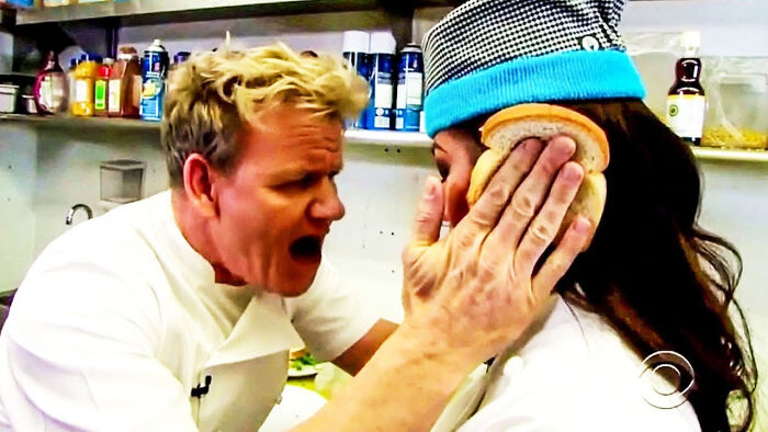 Gordon Ramsay yelling at a chef with a piece of bread on her face, showcasing British humor.
