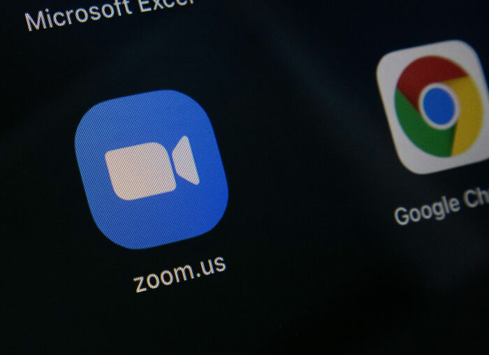 Zoom app icon on a screen. The CEO went viral for firing employees via Zoom.