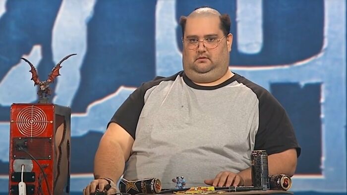 An overweight man with a receding hairline and glasses looking surprised, illustrating dumb reasons couples divorce.