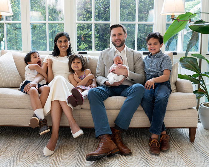 JD Vance, his wife, Usha Vance, and their children, including a newborn son, pose on a couch in a bright room. JD Vance, his wife, Usha Vance, and their children, including a newborn son, pose on a couch in a bright room.
