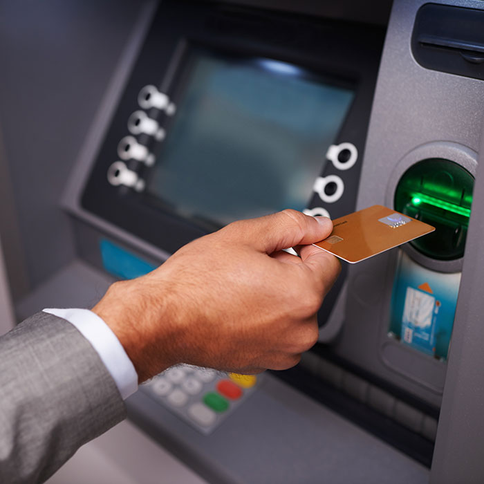 A person inserts a gold credit card into an ATM, a common task, but perhaps related to a weird job.