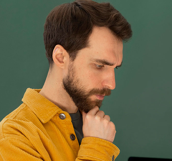 A thoughtful man in a yellow corduroy shirt, contemplating unusual jobs.