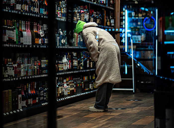 A person in a store aisle, examining bottles, representing unusual jobs.