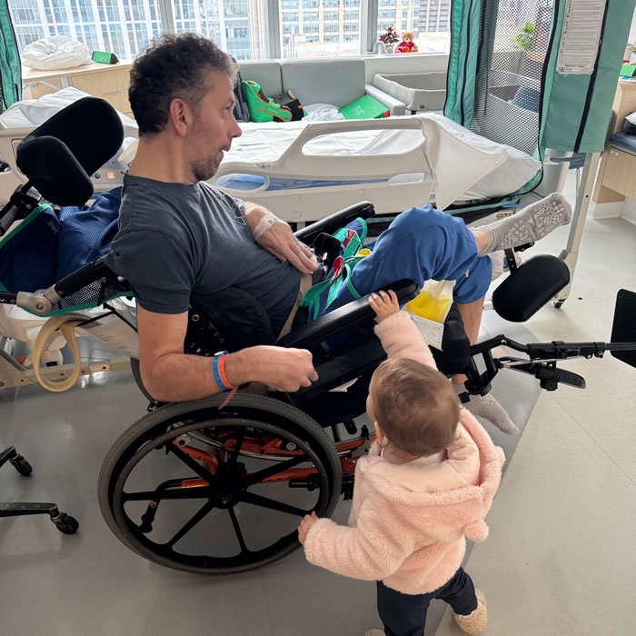 A marine vet, in a wheelchair, interacts with a baby, after suffering brain damage from raw oysters. A marine vet, in a wheelchair, interacts with a baby, after suffering brain damage from raw oysters.