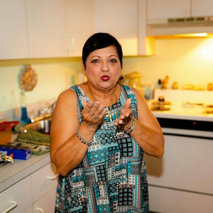 A woman blowing a kiss in a kitchen. Interesting neighbors.