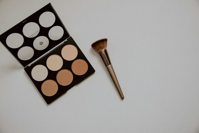 Makeup palette and brush, reflecting a habit some women keep despite being no longer broke.