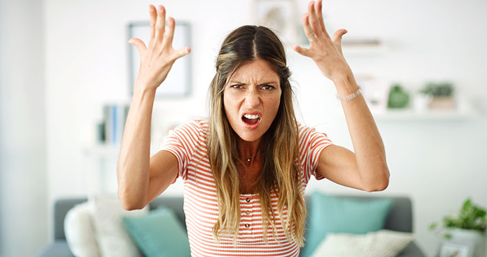 A frustrated woman with hands raised, reacting to a guy's affair getting exposed before a group vacation. A frustrated woman with hands raised, reacting to a guy's affair getting exposed before a group vacation.