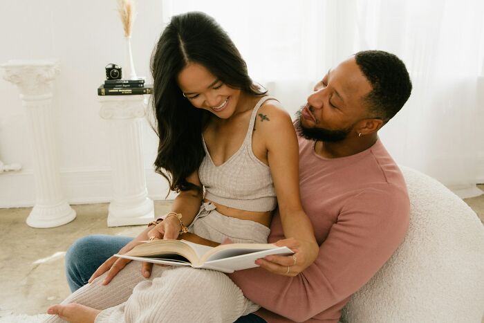 A happy married couple reading a book together, sharing truths about being married.