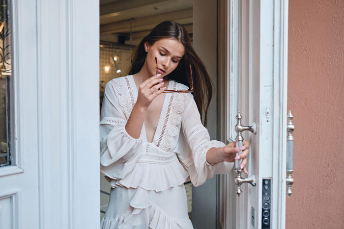 A woman entering a home, symbolizing the sister turning brother's home into her personal lounge. A woman entering a home, symbolizing the sister turning brother's home into her personal lounge.
