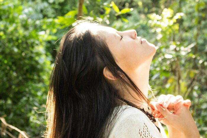 Woman looking up with eyes closed, enjoying sunlight, picking up skills that genuinely changed her life.
