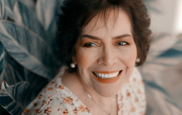 Smiling woman with vibrant eyes, representing stories from people who crossed the line between life.