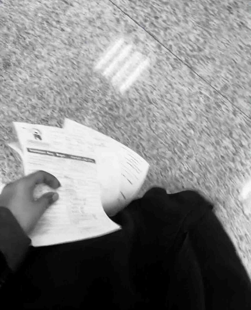 A person holding papers, possibly related to a new side hustle opportunity.