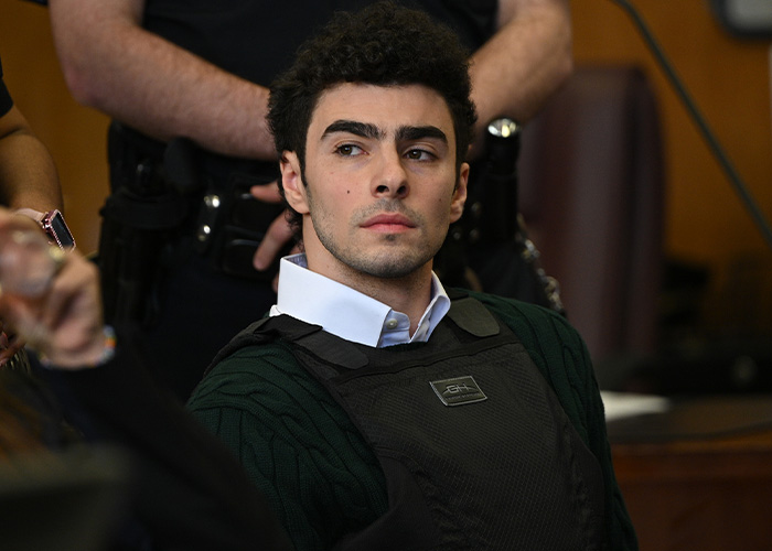 Luigi Mangione case update: Young man with curly hair in a vest, looking thoughtful during his court appearance. Luigi Mangione case update: Young man with curly hair in a vest, looking thoughtful during his court appearance.