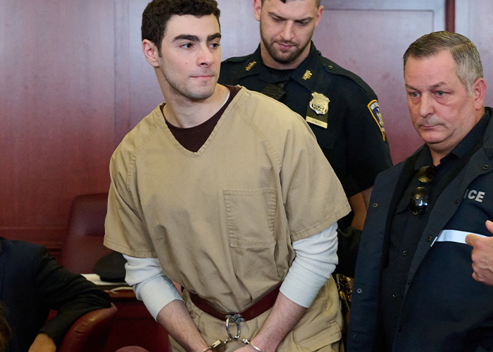 Luigi Mangione case update: Luigi Mangione in handcuffs and an orange jumpsuit, escorted by officers. Luigi Mangione case update: Luigi Mangione in handcuffs and an orange jumpsuit, escorted by officers.