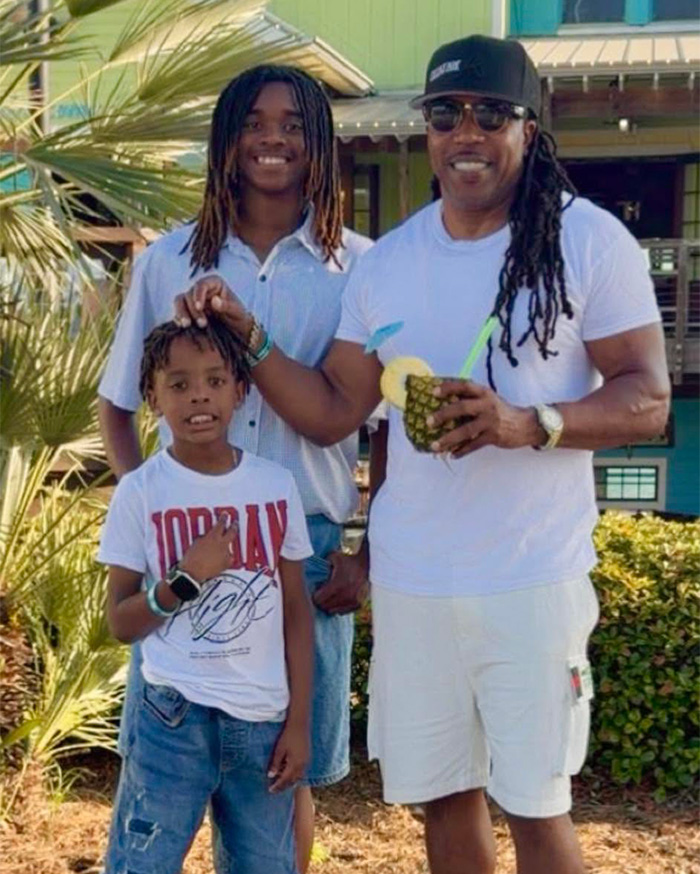 Black dad with kids at pool enjoying a sunny day outdoors. Black dad with kids at pool enjoying a sunny day outdoors.