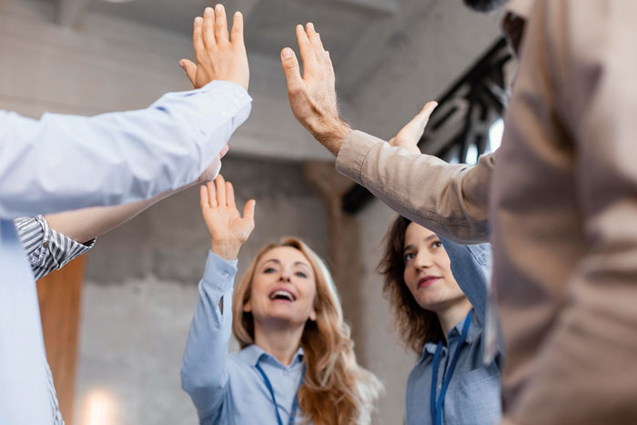 Employees giving a high five, representing the employer trying to celebrate a man who didn't show up for 6 years. Employees giving a high five, representing the employer trying to celebrate a man who didn't show up for 6 years.