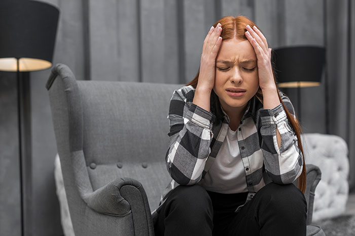 Wife on edge: a woman with red hair looking distressed, holding her head, symbolizing being put on edge by hubby's questions. Wife on edge: a woman with red hair looking distressed, holding her head, symbolizing being put on edge by hubby's questions.