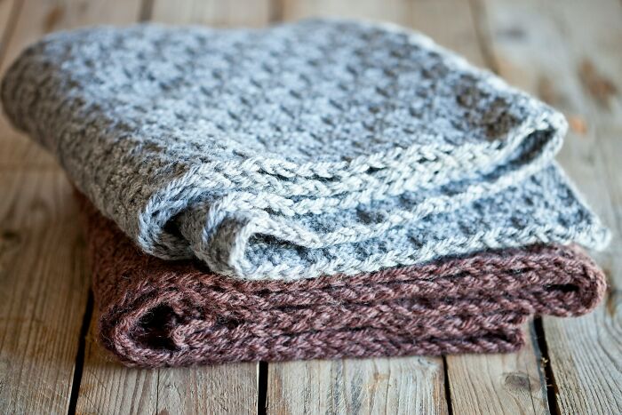 Two folded knit blankets, symbolizing the warmth and comfort found in truths about being married.