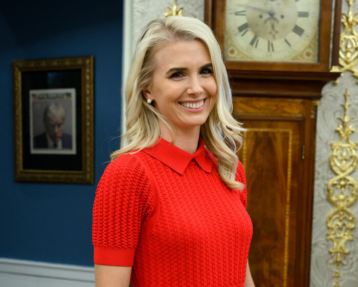 A female aide, central to the president's aide scandal, smiles in an indoor setting. A female aide, central to the president's aide scandal, smiles in an indoor setting.
