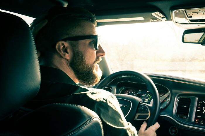 A man drives a car, possibly realizing he's with the wrong person.