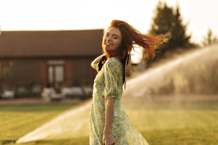 A woman smiles in a field, wind blowing her hair. Her friendship ends with hurtful messages, dispute. A woman smiles in a field, wind blowing her hair. Her friendship ends with hurtful messages, dispute.