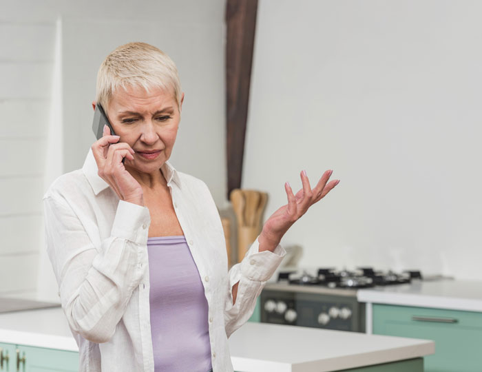 An elderly woman on the phone, visibly upset, depicting the selfish mom who only cares about bills. An elderly woman on the phone, visibly upset, depicting the selfish mom who only cares about bills.