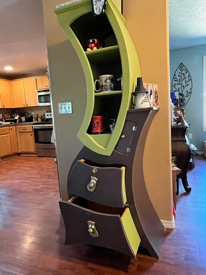 A unique, quirky DIY home project of a custom-built, wavy cabinet with open shelves and drawers, adding character to the space.