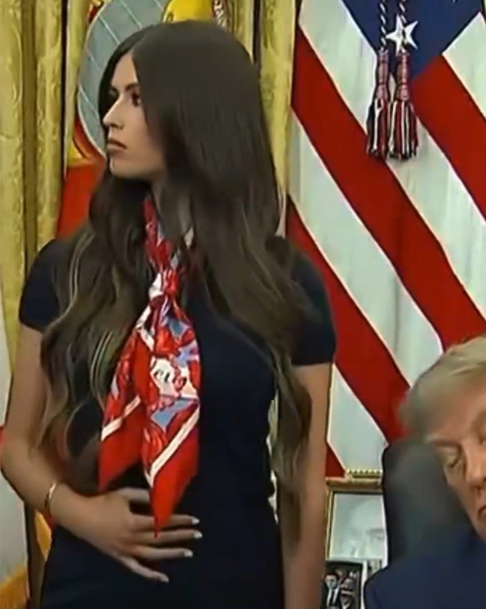 Close-up of the mystery woman behind Trump, showing her strange gesture and red scarf.