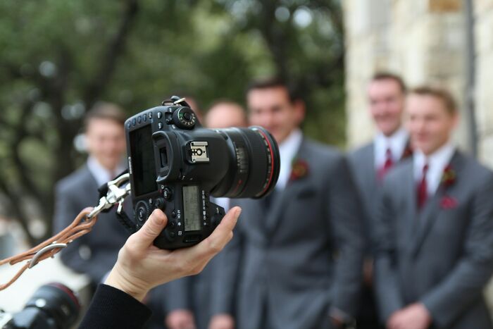 A camera focused on a group of groomsmen, capturing wedding moments.