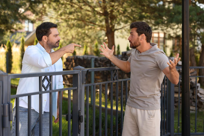 Two men, a rude neighbor and a new parent, arguing at a fence about illegal antenna noise, causing disturbance. Two men, a rude neighbor and a new parent, arguing at a fence about illegal antenna noise, causing disturbance.