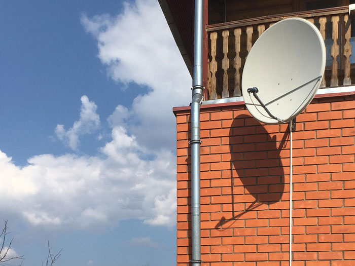 Image of an illegal antenna on a brick house, used by a rude neighbor blasting radio, disturbing new parents. Image of an illegal antenna on a brick house, used by a rude neighbor blasting radio, disturbing new parents.