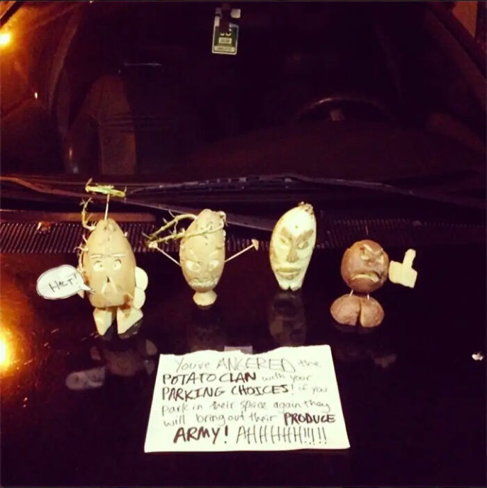Four potato figures on a car's dashboard with a note about angering the potato clan with parking choices. Jerk neighbors and parking.