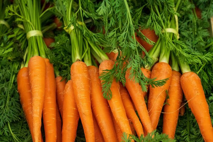 Freshly harvested carrots with green tops, suggesting common misconceptions about healthy eating.