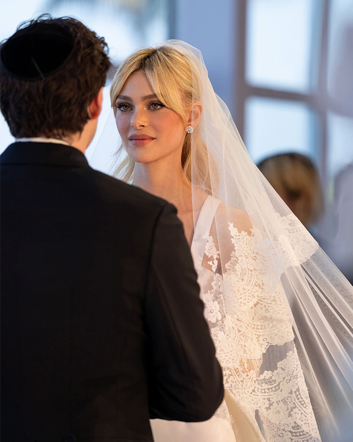 Brooklyn and Nicola Peltz Beckham during their wedding ceremony, showcasing the bride's elegant veil and gown. Brooklyn and Nicola Peltz Beckham during their wedding ceremony, showcasing the bride's elegant veil and gown.