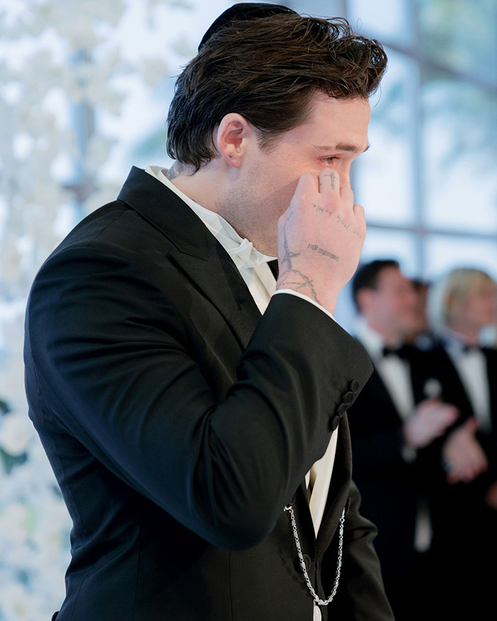 Brooklyn Beckham crying at his wedding, wiping a tear from his eye, during the emotional ceremony. Brooklyn Beckham crying at his wedding, wiping a tear from his eye, during the emotional ceremony.