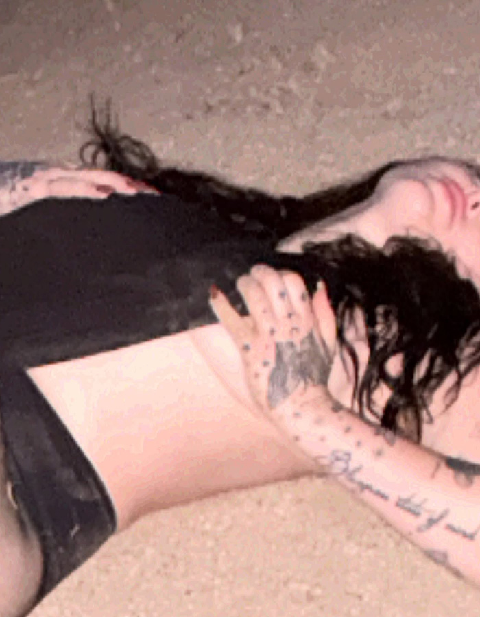 Miley Cyrus's little sister Noah lying on the ground in a risky black outfit during a bizarre desert photoshoot. Miley Cyrus's little sister Noah lying on the ground in a risky black outfit during a bizarre desert photoshoot.