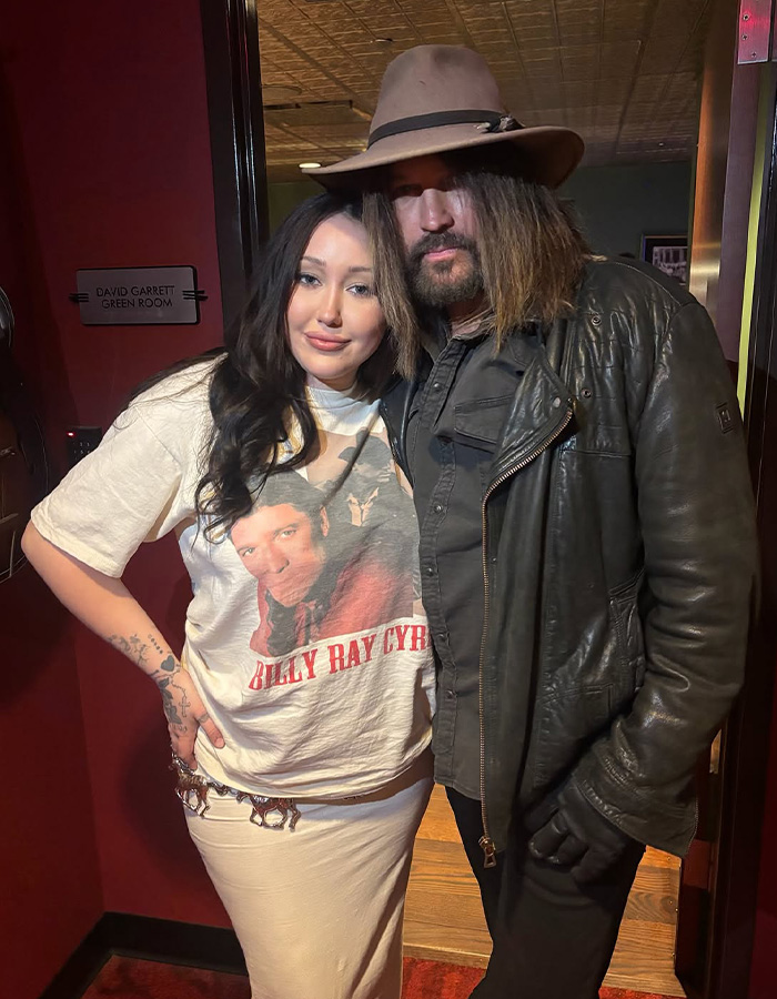 Miley Cyrus' little sister, Noah Cyrus, with her father, Billy Ray Cyrus, both looking at the camera. Miley Cyrus' little sister, Noah Cyrus, with her father, Billy Ray Cyrus, both looking at the camera.