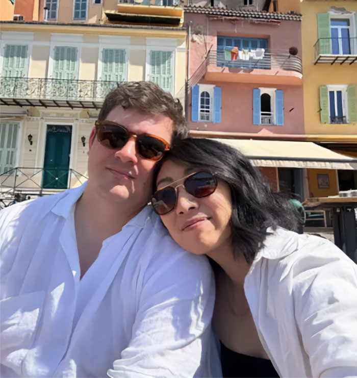 American Mom and partner smiling in France, discussing kids' school lunch. American Mom and partner smiling in France, discussing kids' school lunch.