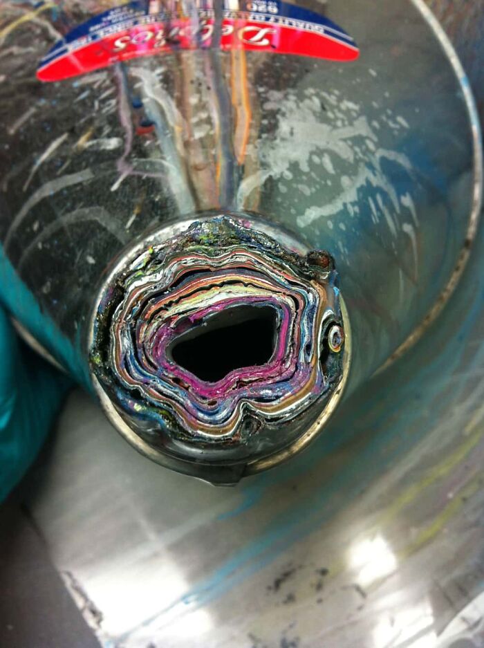 Interesting and surprising photo of a paint tube cut in half, revealing colorful layers inside.
