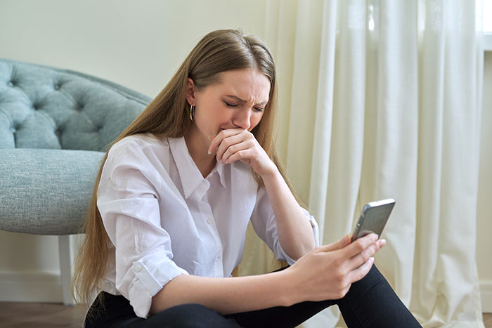A woman crying while looking at her phone, drawing the line at her wedding due to her family protecting her toxic BIL. A woman crying while looking at her phone, drawing the line at her wedding due to her family protecting her toxic BIL.