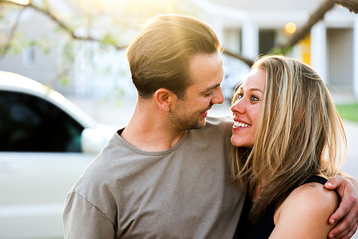 Smiling GF and BF having female friends. The GF looks happy and content with her BF.