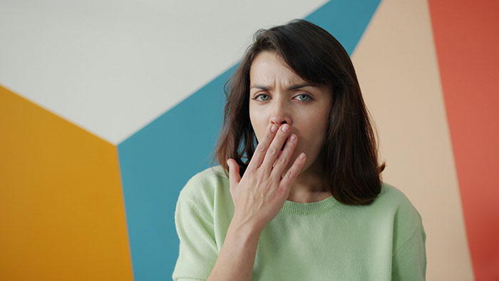 A concerned woman covers her mouth, reflecting the GF's discomfort with her BF having female friends.