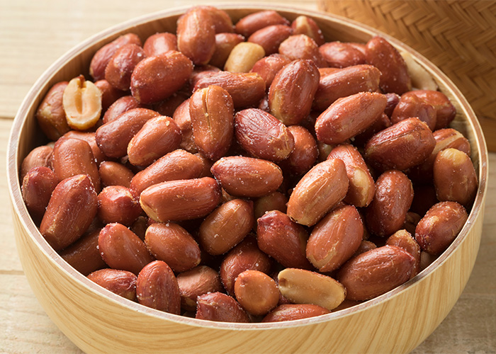 A bowl of peanuts, highlighting the debate about eating peanuts on a plane when other travelers have allergies. A bowl of peanuts, highlighting the debate about eating peanuts on a plane when other travelers have allergies.