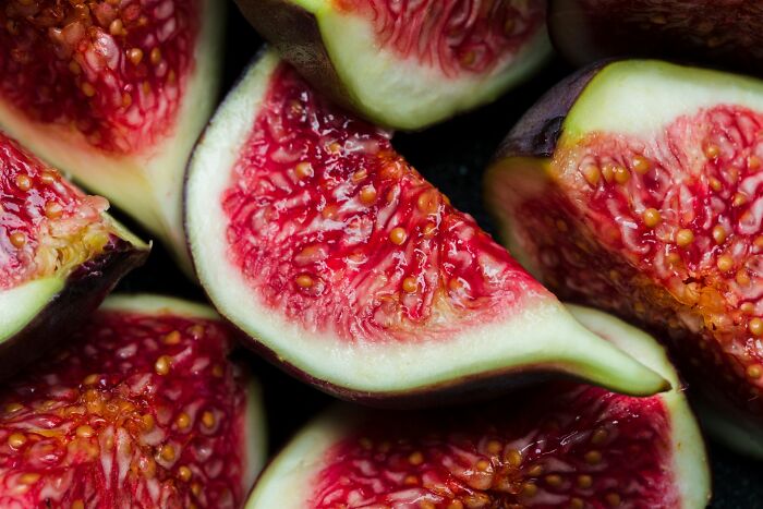 A close-up of sliced figs with red flesh and tiny seeds, an example of scary science facts in nature.