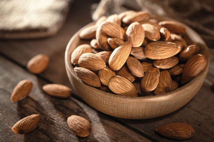 A wooden bowl filled with almonds, visually linking to the term Almondsexual and evolving identity. A wooden bowl filled with almonds, visually linking to the term Almondsexual and evolving identity.