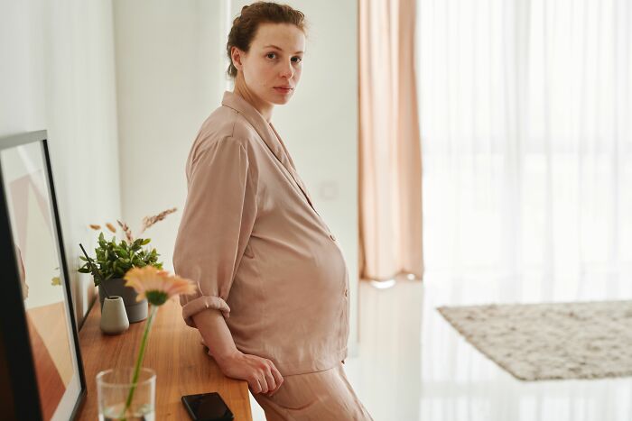 A pregnant woman in a living room, perhaps thinking about raising children after being raised by narcissists.
