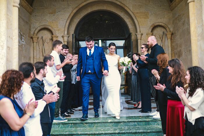A newlywed couple walking down steps as guests applaud, reflecting on how being raised by narcissists affects relationships.