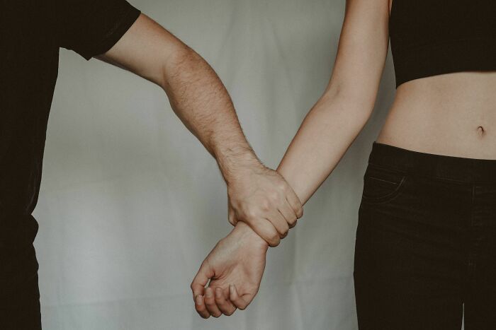 A man grabbing a woman's arm, symbolizing the control and pain from being raised by narcissists.