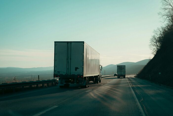 Scariest things witnessed: Two large trucks drive on a highway with mountains in the background, implying a long journey.