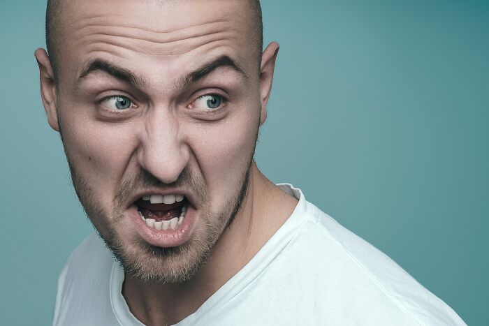 A man with a bald head and beard, yelling with an angry expression. This image evokes scariest things people witness.